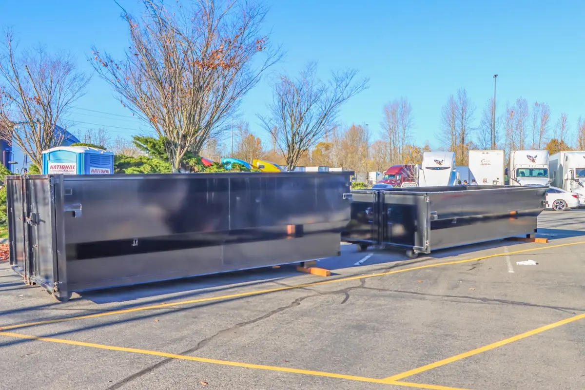 Professional dumpster rental service with roll-off container on residential driveway in Yucca Valley